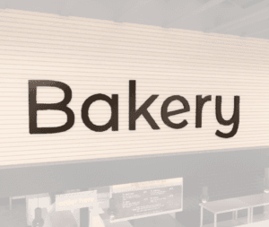 Modern collection wall copy dimensional letters for Bakery department wayfinding. Copy has aluminum face and finished edges.