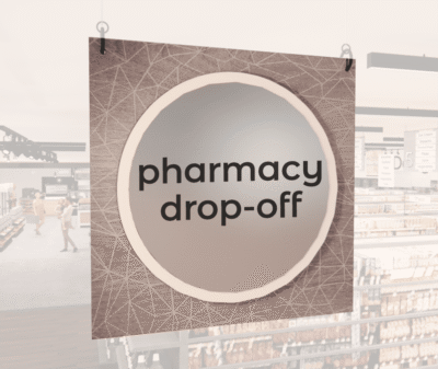 Modern Collection's large department sign with digitally printed text "pharmacy drop-off" centered on a circular overlay.