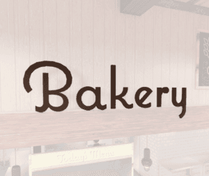 Natural Collection's wayfinding Bakery department sign that is wall mounted with dimensional wood letters and a painted finish