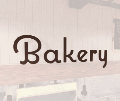 Natural Collection's wayfinding Bakery department sign that is wall mounted with dimensional wood letters and a painted finish