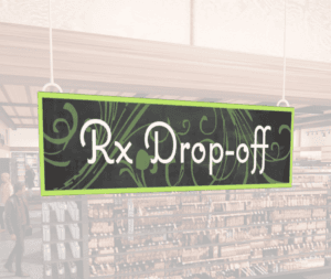 Natural Collection's wayfingding hanging department sign that has "RX Drop-off," digitially printed in white text and on PVC