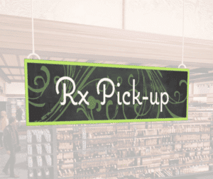 Natural Collection's wayfingding hanging department sign that has "RX Pick-up," digitially printed in white text and on PVC.