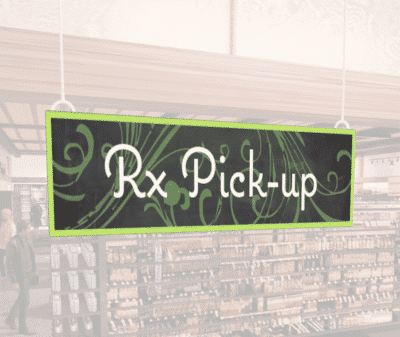 Natural Collection's wayfingding hanging department sign that has "RX Pick-up," digitially printed in white text and on PVC.