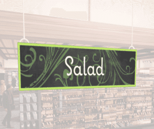 Natural Collection's wayfingding hanging department sign that has "Salad," digitially printed in white text and on PVC.