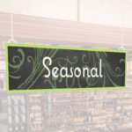 Natural Collection's wayfingding hanging department sign that has "Seasonal," digitially printed in white text and on PVC.