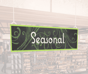 Natural Collection's wayfingding hanging department sign that has "Seasonal," digitially printed in white text and on PVC.