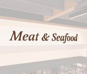 Traditional Collection's wayfinding Meat dept sign with the text "Meat & Seafood," in dimensional painted wood letters.
