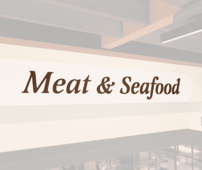 Traditional Collection's wayfinding Meat dept sign with the text "Meat & Seafood," in dimensional painted wood letters.